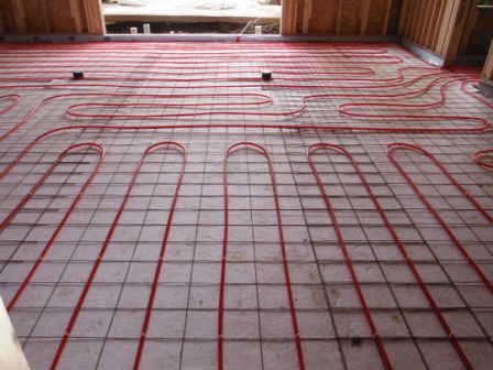 Picture of the installation of in floor radiant heating pipe on foundation floor.