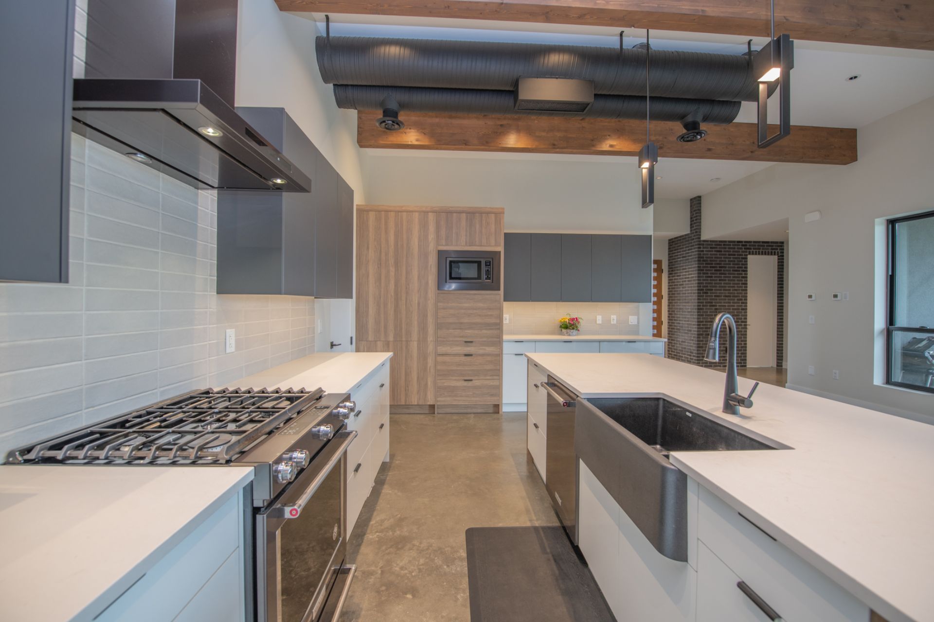 Photo of feature exposed ductwork & open structural wood beams in contemporary kitchen.