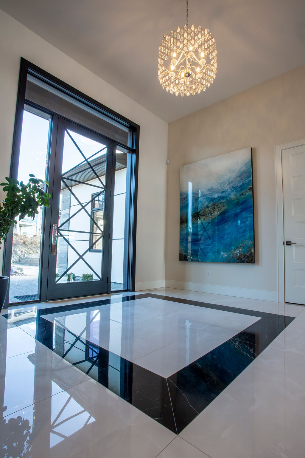 Photo of glass doored entry, with white marble flooring with black accent.